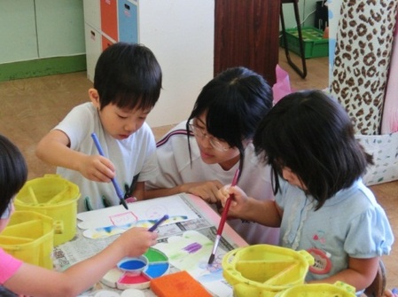 幼児と浜高生が絵を描いています
